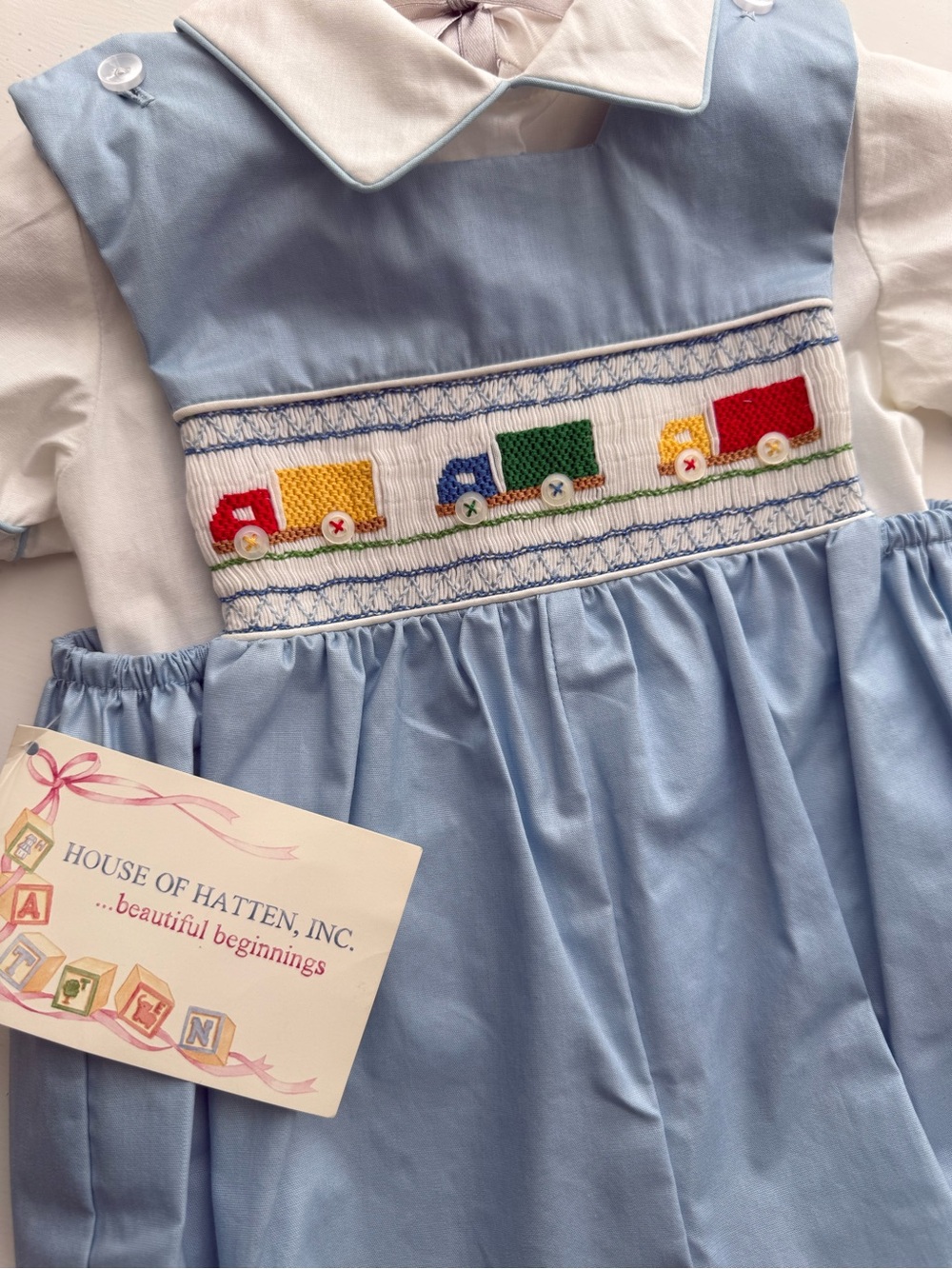 House of Hatten Smocked Blue & White Baby Romper with Colorful Truck Motif